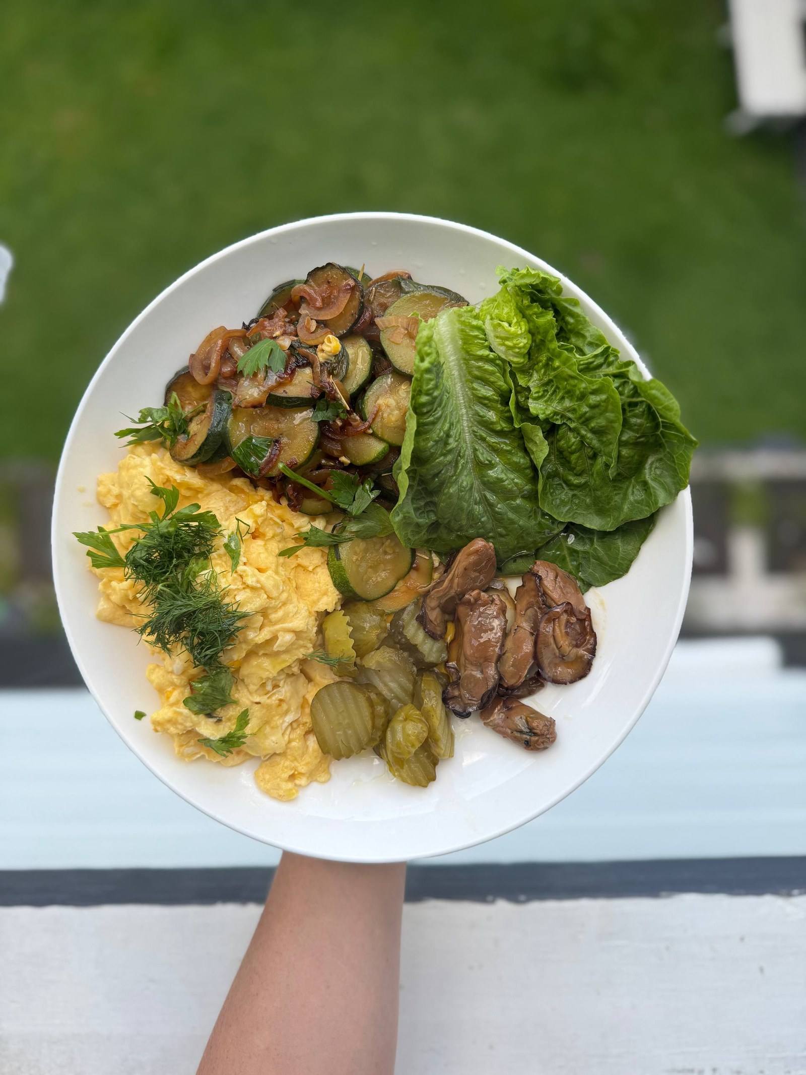 A nourishing plate of scrambled eggs, sauteed zucchini, cos lettuce, pickles and mushrooms