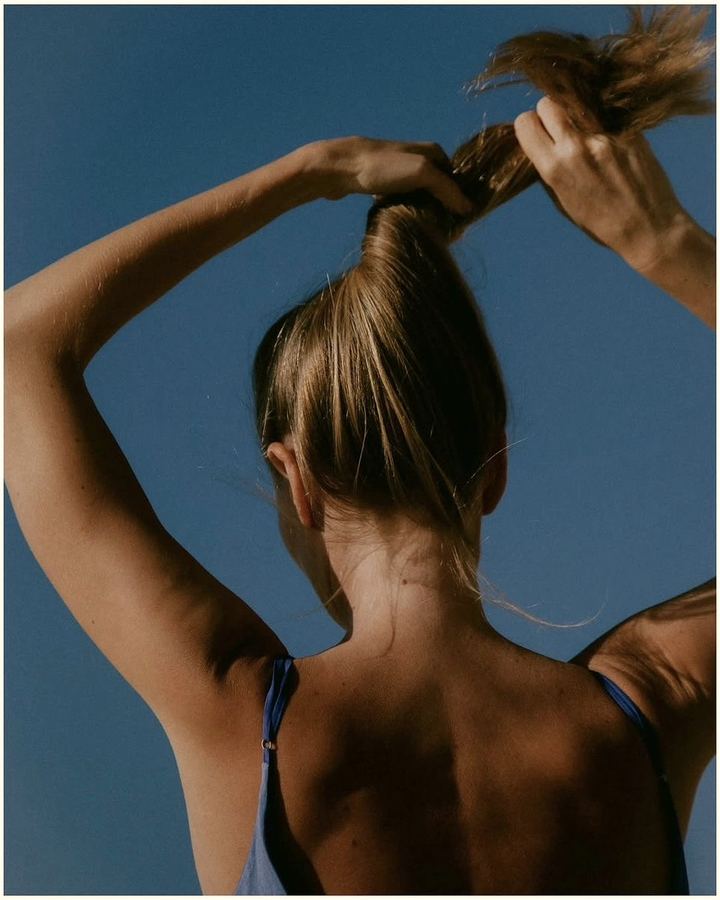 Back and hair against open sky.
