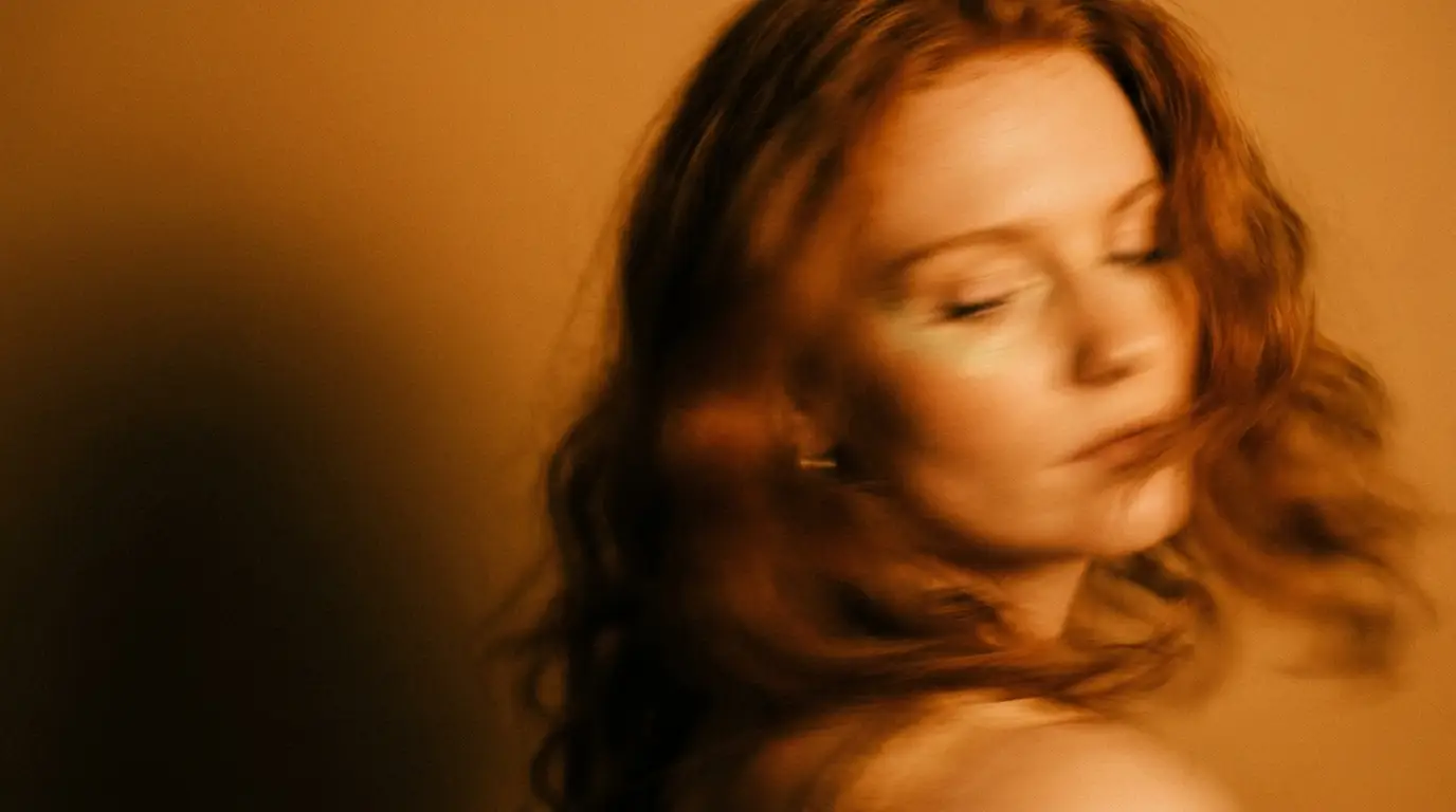 Warm low light on a midlife woman resting with eyes closed
