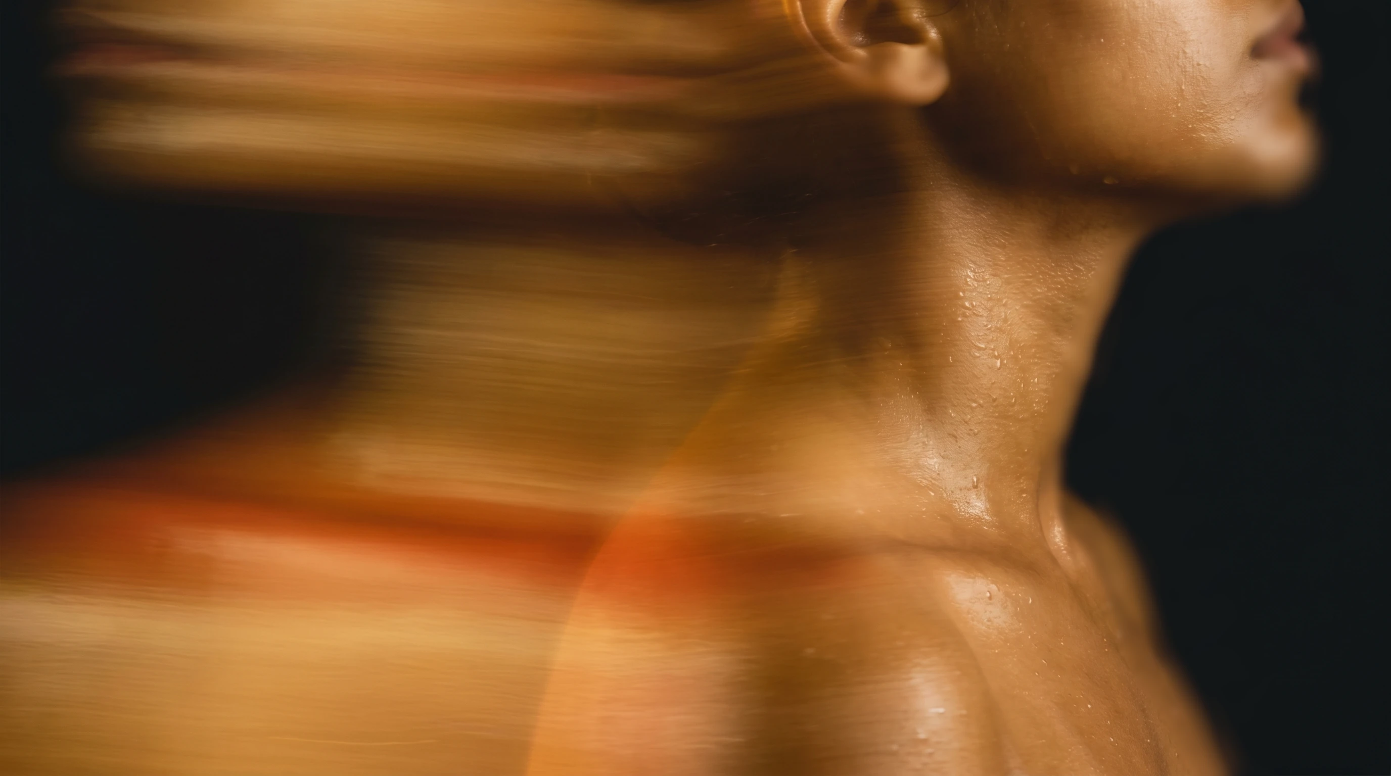 A woman's profile and shoulder, warm gold light catching wet skin, dragging into painterly motion against a charcoal void
